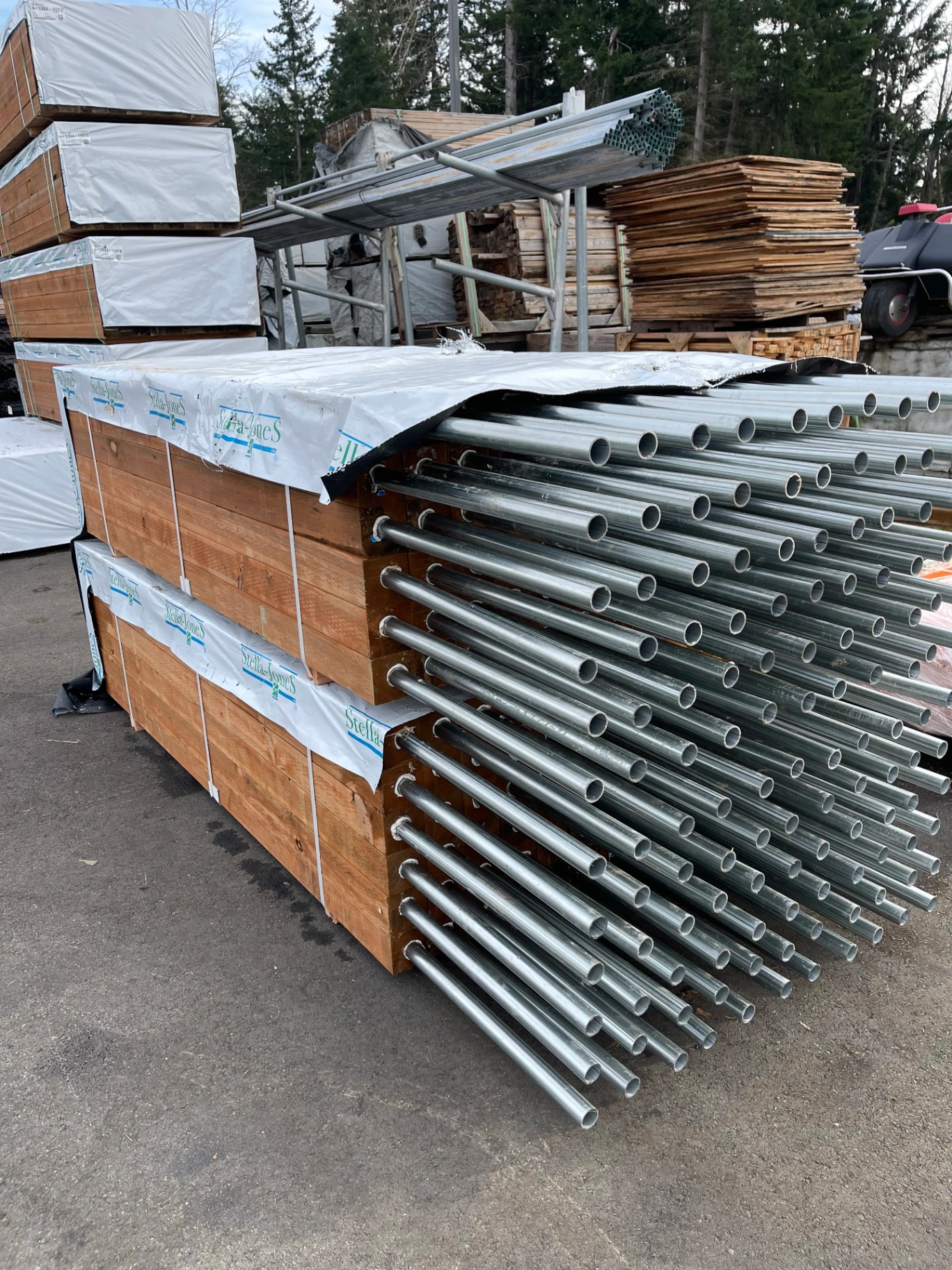 Stacked fence panels with galvanized steel pipes ready for installation