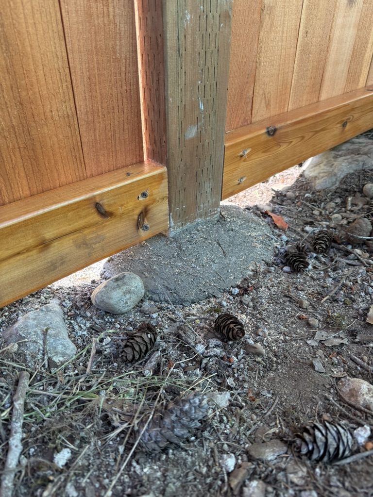 Raised concrete mound keeping the fence post above surrounding soil