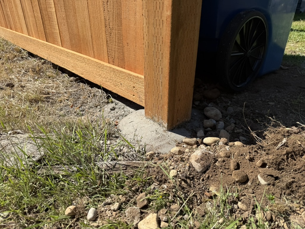 Mounded concrete footing with a smooth troweled dome shedding away from the post