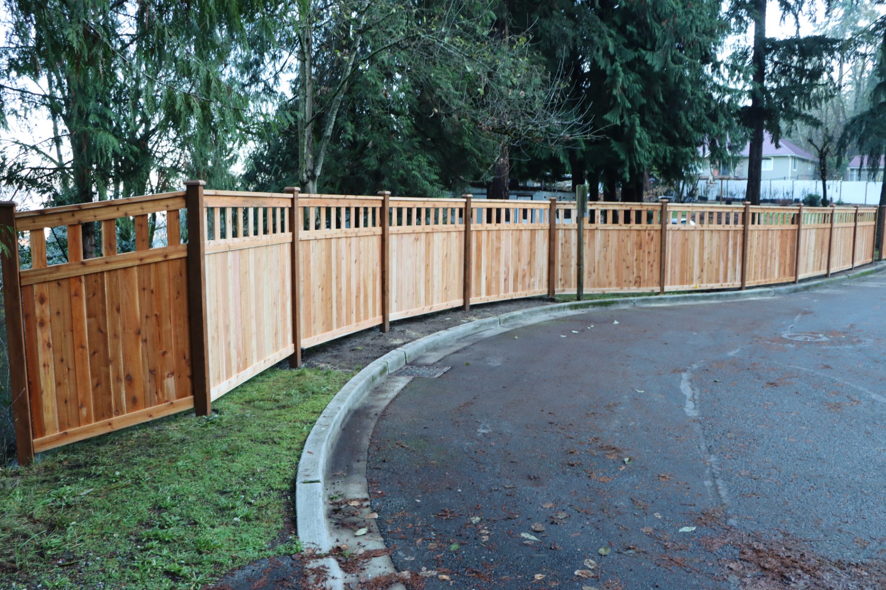Long run of craftsman style fence along street with alternating boards