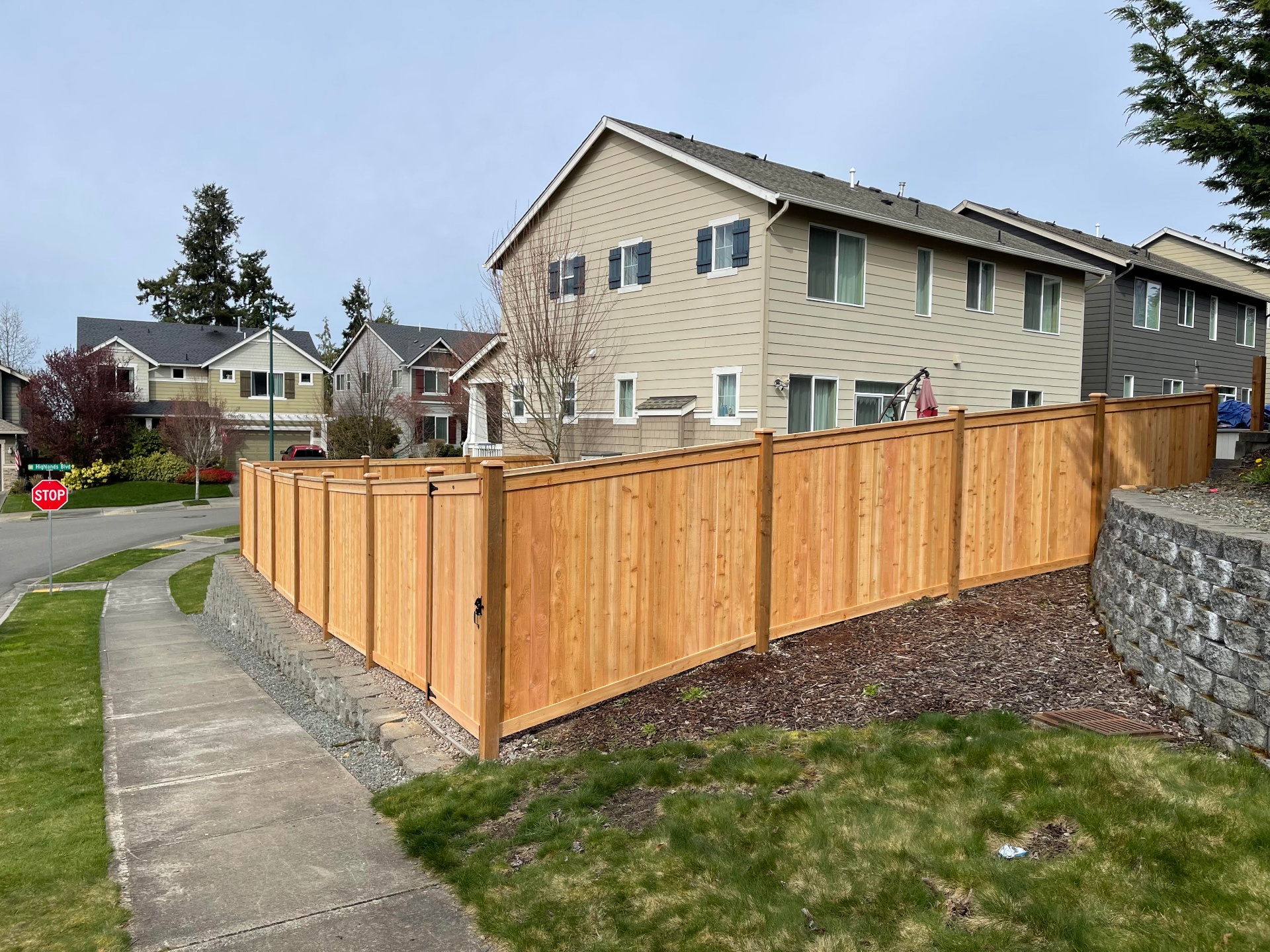 Neighborhood corner lot picture frame cedar fence with gate