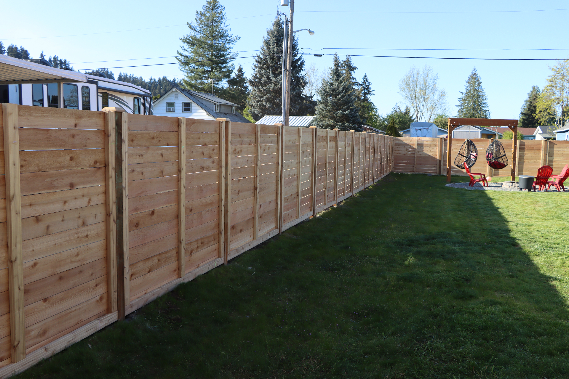 Long horizontal cedar fence in residential backyard