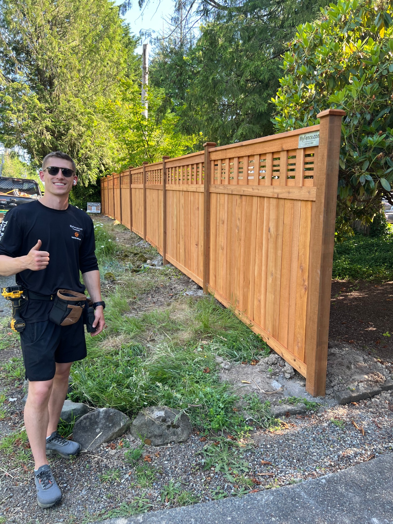 Professional installer with completed horizontal lattice fence project