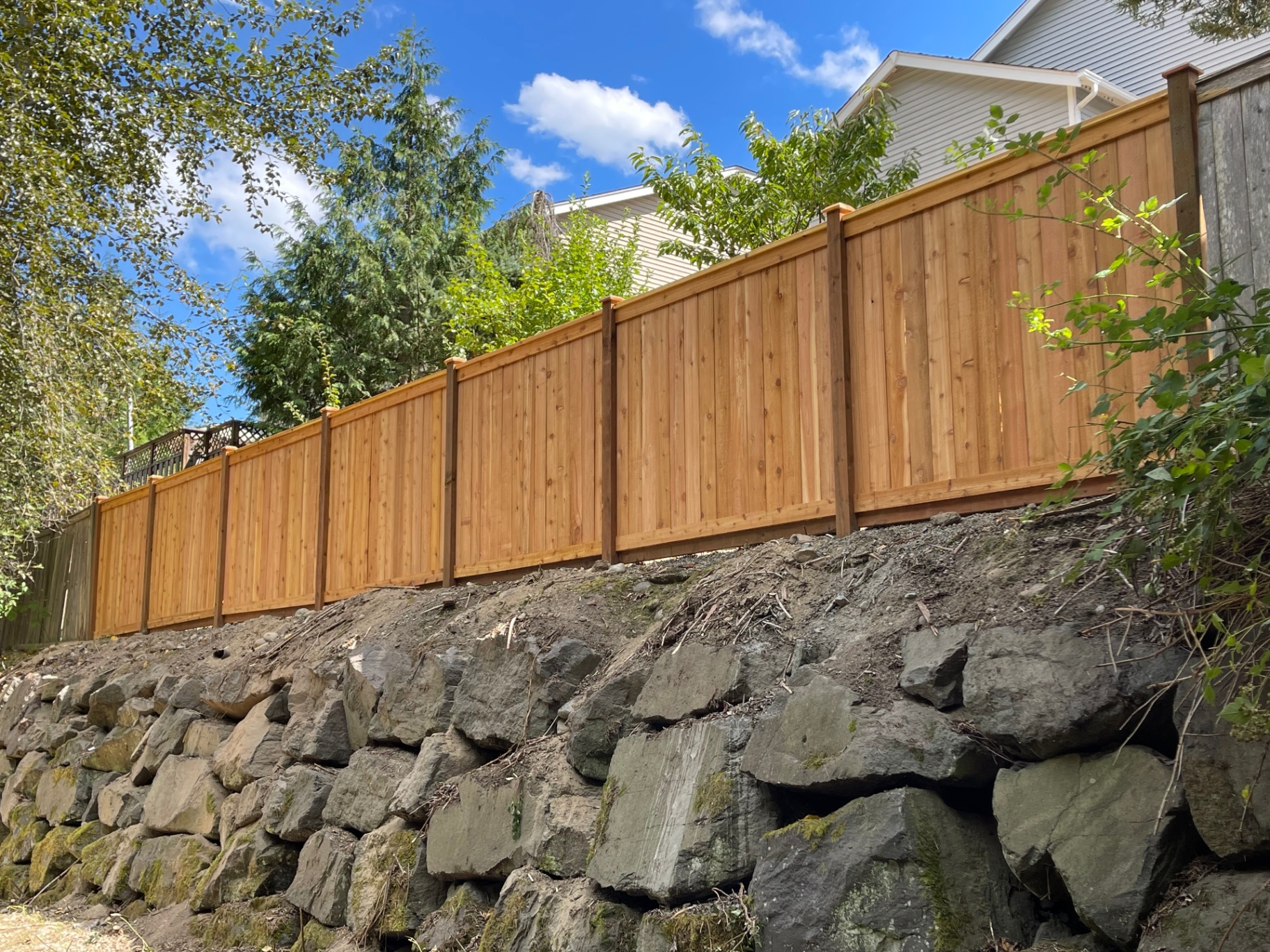 Picture frame cedar fence on rock retaining wall