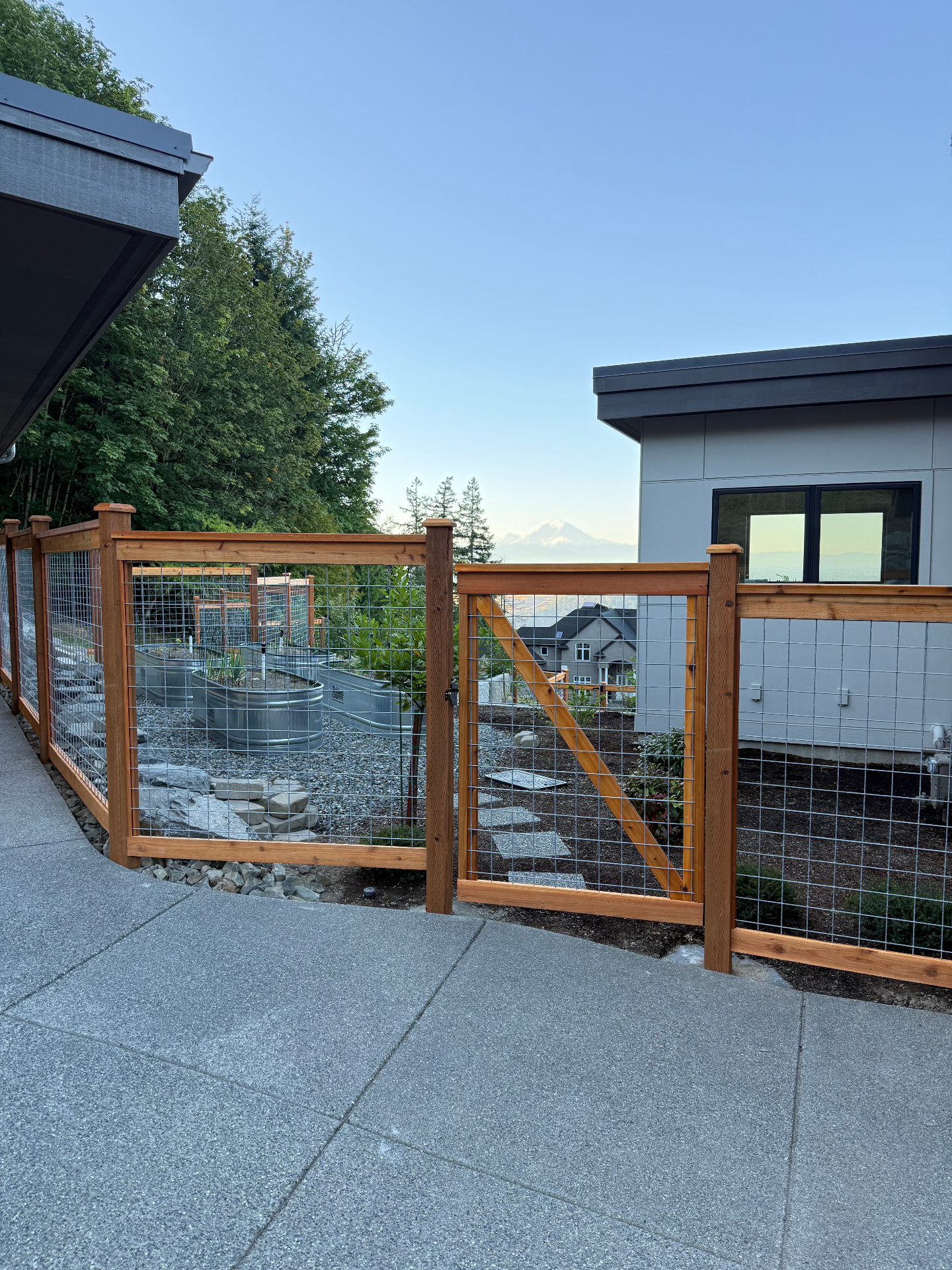 Galvanized hogwire fence with cedar frame showcasing modern home installation