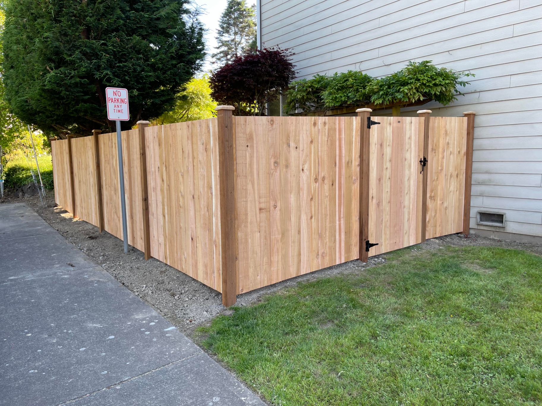 New cedar solid board fence installation with clean lines and professional construction