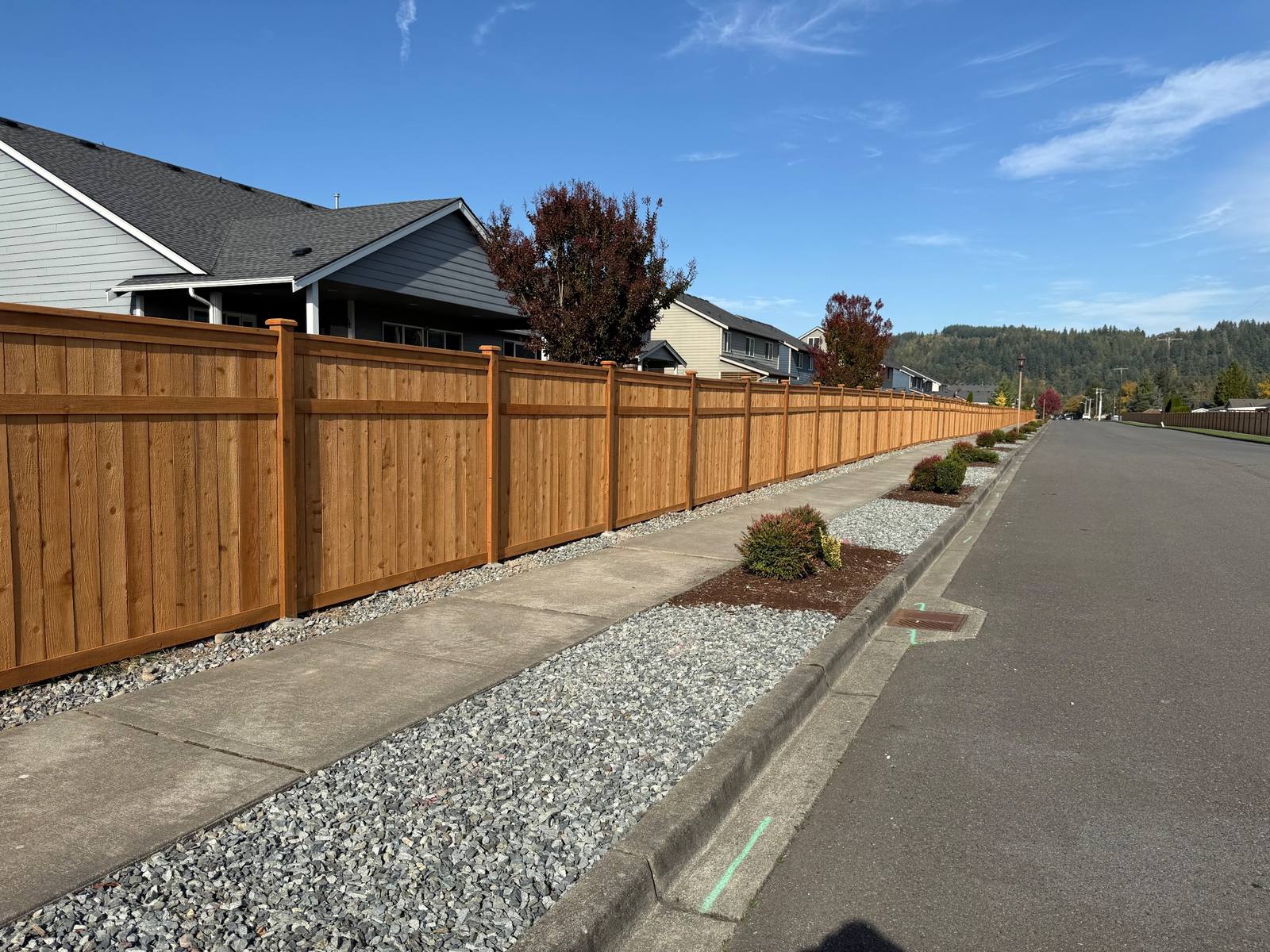 Sherwin-Williams stained cedar 3-rail picture frame fence along a neighborhood street in Orting, WA