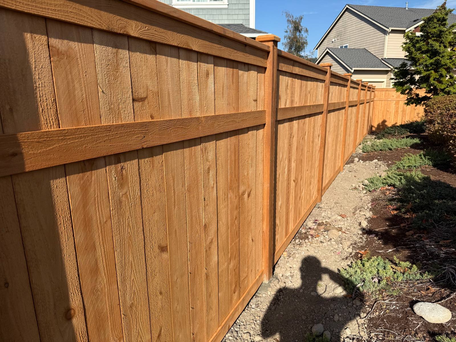Close-up of a Sherwin-Williams stained cedar 3-rail picture frame fence in Orting, WA